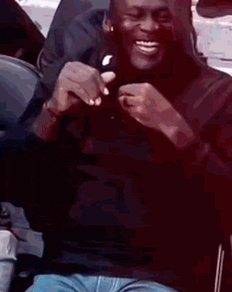 a man is sitting in a chair and smiling while holding a piece of food .