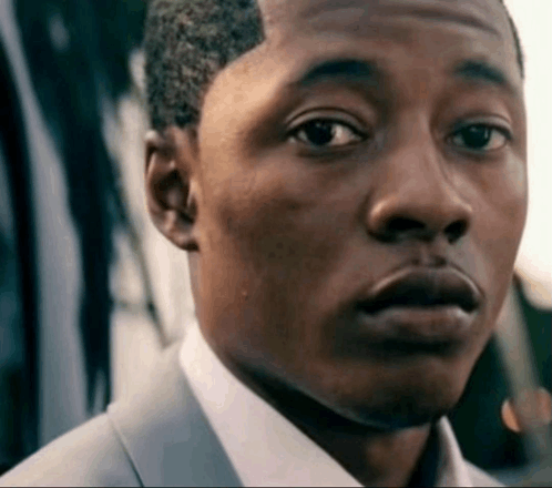 a close up of a man 's face in a suit and white shirt