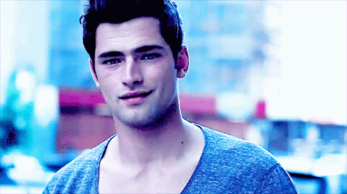 a close up of a man 's face with a blue shirt on