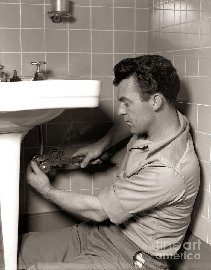 plumber-fixing-bathroom-sink-c1950s-h-armstrong-robertsclassicstock.jpg