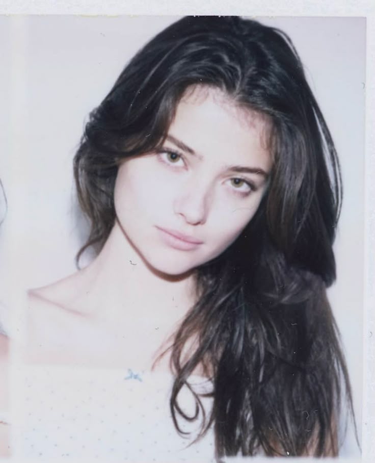 This may contain: an old photo of a woman with long hair