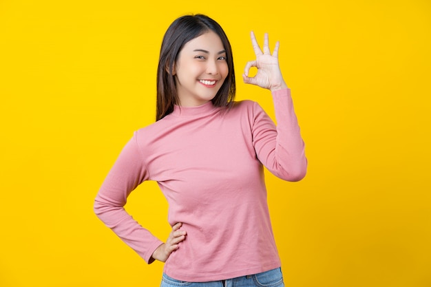 asian-smiling-young-woman-gesturing-ok-sign-approval-agreement-isolated-yellow-wall_41418-3643.jpg