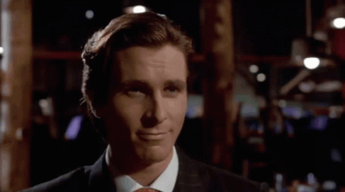 a man in a suit and tie is smiling in a dark room .