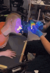 a person wearing blue gloves is holding a purple object in their hand