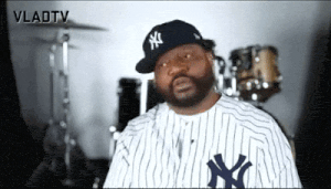 a man wearing a ny hat and a striped shirt