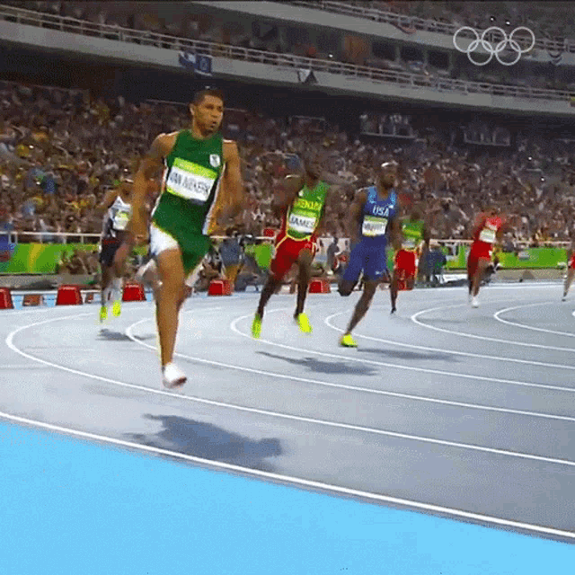 a group of athletes are running on a track and one of them has a name tag that says ram aiken