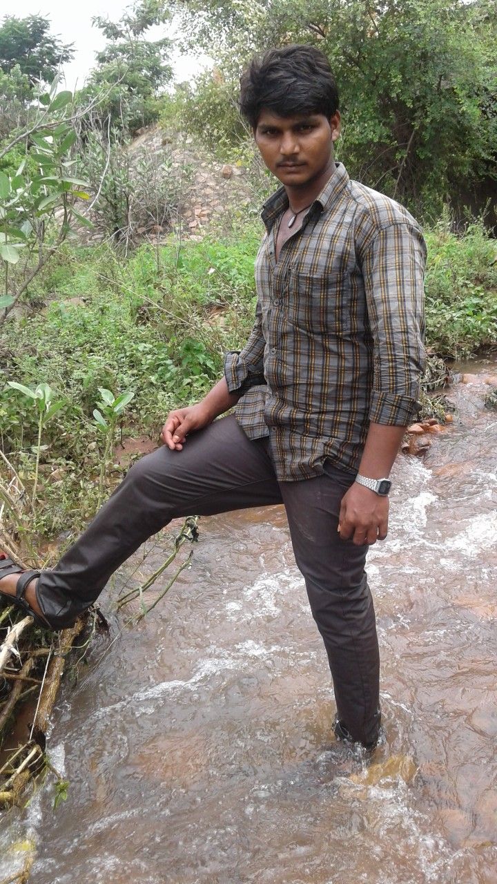 This may contain: a man standing on top of a river next to a forest