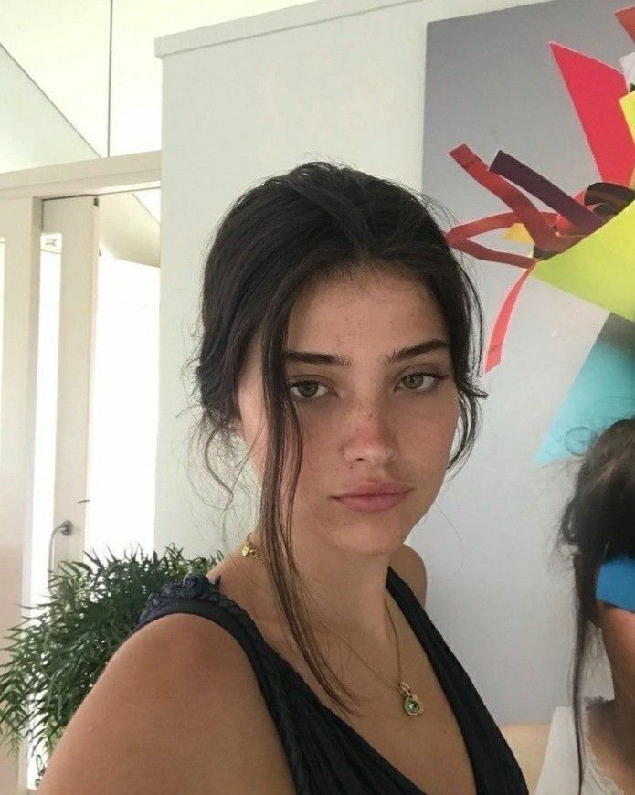 This may contain: a woman is standing in front of a painting