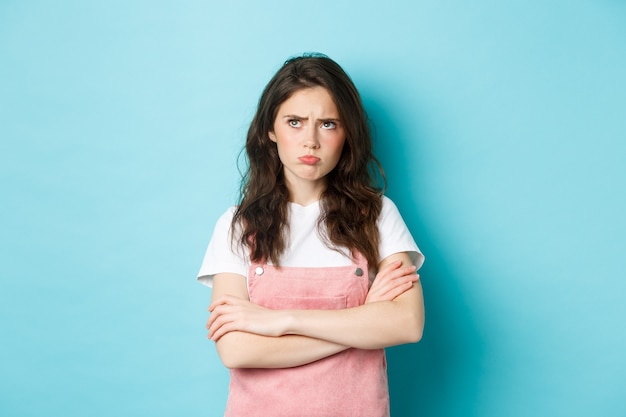 disappointed-sad-brunette-girl-pouting-cross-arms-chest-looking-upper-left-corner-unfair-thing-angry-person-standing-against-blue-background_1258-69971.jpg