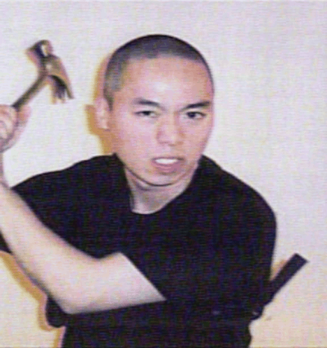 a man in a black shirt is holding a hammer in his right hand