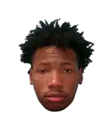 a young man with dreadlocks looks at the camera with a serious look on his face