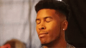 a man with his eyes closed is wearing earring studs