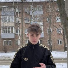 a young man standing in front of a building