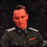 a man in a military uniform says  three glasses  while making a peace sign