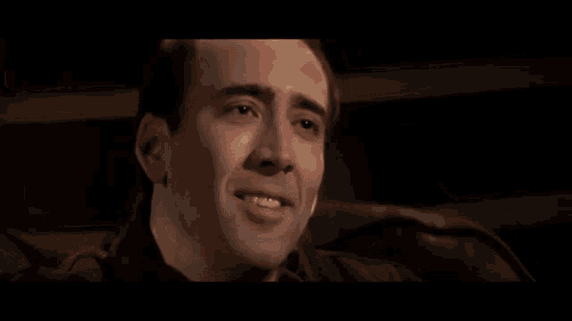 a man is smoking a cigarette and looking at the camera