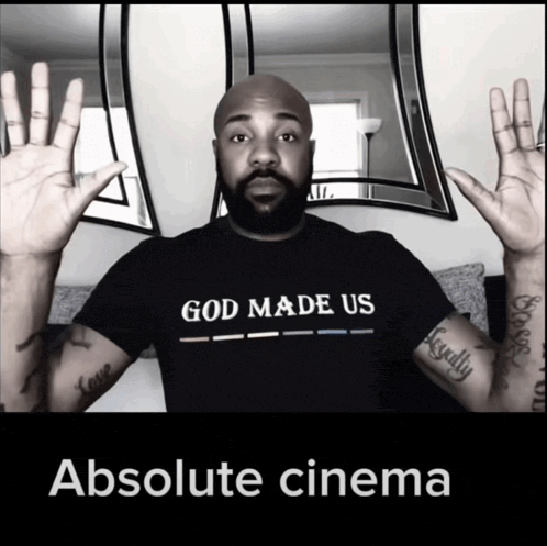 a man wearing a black shirt that says god made us absolute cinema