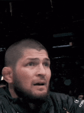 a man with a beard is wearing a black jacket with ufc on it