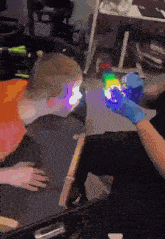 a person is holding a glow in the dark cube in front of a child .