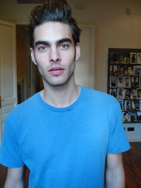 This may contain: a man in a blue t - shirt looking at the camera