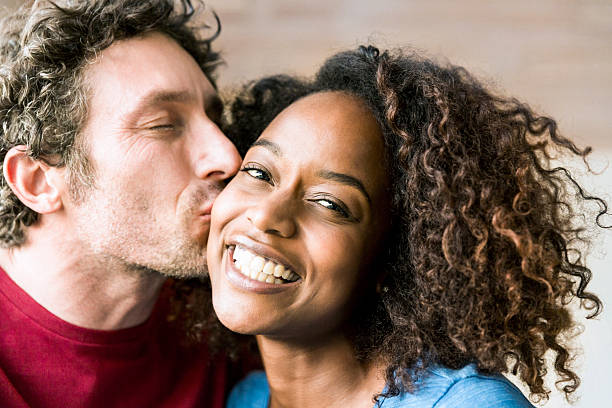 closeup-of-man-kissing-cheerful-woman-on-cheek-picture-id627856598