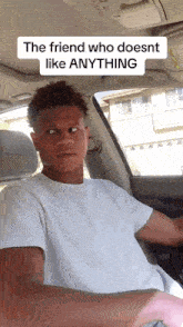 a man in a white shirt is sitting in a car with a caption that says the friend who does nt like anything