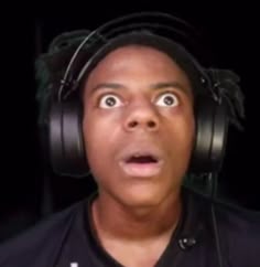 This may contain: a man wearing headphones and making a surprised face with his eyes wide open in front of him