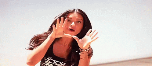 a woman wearing a victoria 's secret tank top making a funny face