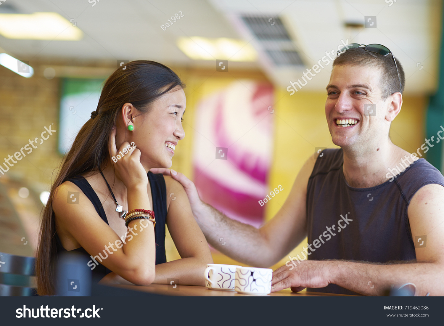 stock-photo-happy-asian-girl-talking-with-white-man-in-the-cafe-719462086.jpg