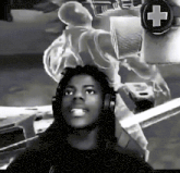 a black and white photo of a man wearing headphones with a cross in the background