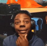 a man wearing headphones looks at the camera with a sign in the background that says super smash bros