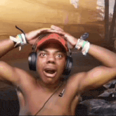 a shirtless man wearing headphones and a red hat with the letter r on it