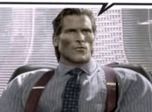 a man in a suit and tie is sitting in front of a window with a speech bubble .