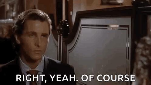 a man in a suit and tie is standing in front of a bed and says `` right , yeah , of course '' .