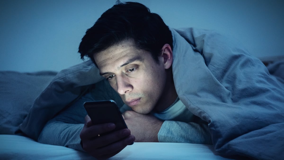 Oneitis_-Man-in-Bed-with-Phone-Sad-Waiting-for-a-Text-Message-From-His-Crush.jpg