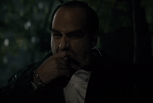 a man in a tuxedo is smoking a cigarette
