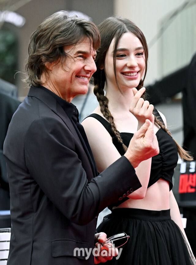 This may contain: two people standing next to each other on a red carpet
