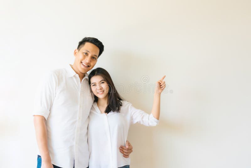 happy-asian-couple-pointing-finger-empty-copy-space-wall-happy-asian-couple-white-shirt-smiling-pointing-finger-157505513.jpg