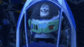 buzz lightyear from toy story is smiling while sitting in a spaceship .
