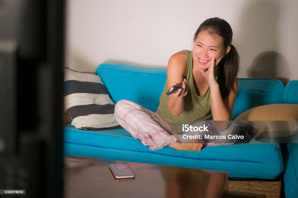 home-lifestyle-portrait-of-young-happy-and-beautiful-asian-chinese-woman-watching-tv-at.jpg