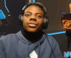 a man wearing headphones looks at the camera with a twitter logo behind him