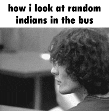 a black and white photo of a man looking at random indians in the bus .