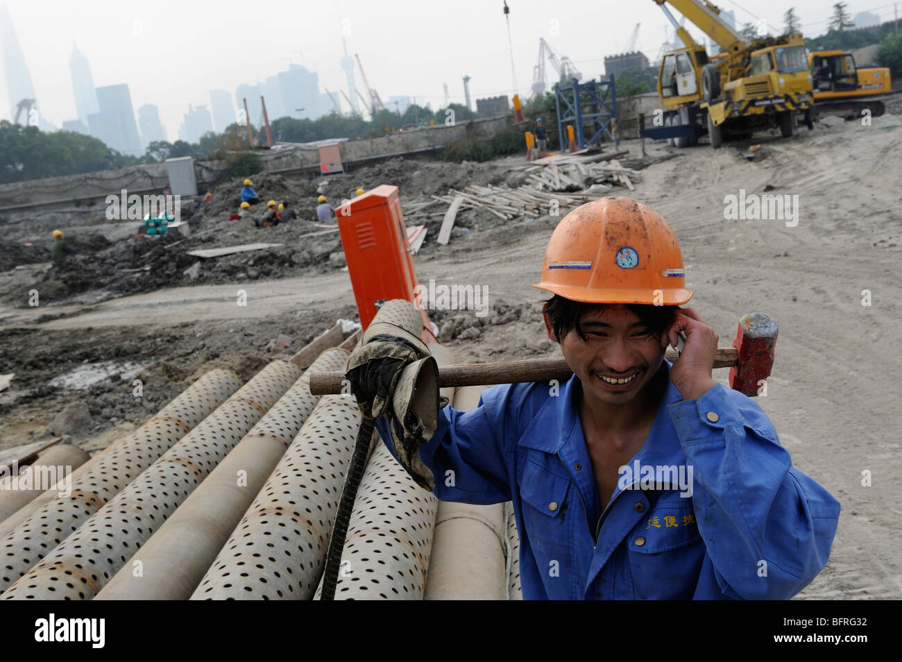 chinese-worker-using-his-moblie-phone-in-a-construction-site-in-shanghai-BFRG32.jpg
