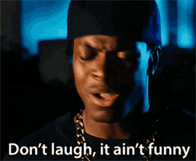 a man wearing a black hat and a gold chain says  do n't laugh it ain 't funny 