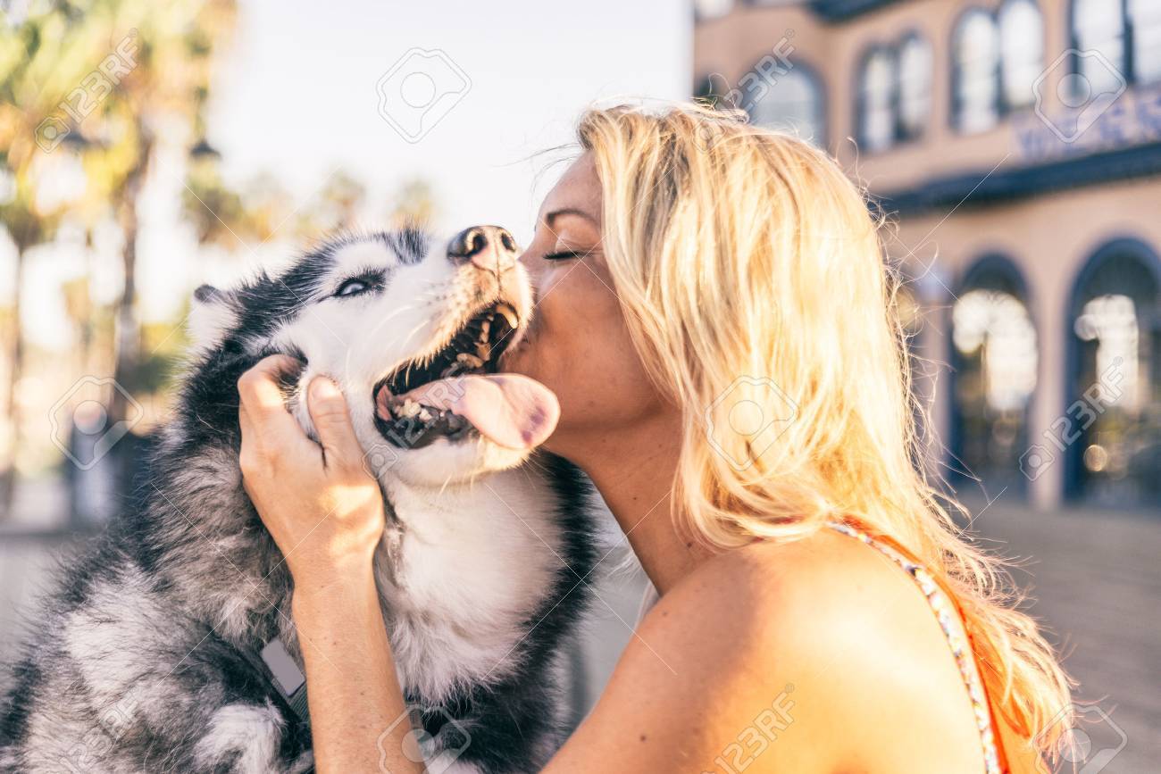 50576452-beautiful-blonde-woman-stroking-her-dog-outdoors.jpg