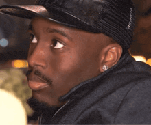 a close up of a man wearing a black hat