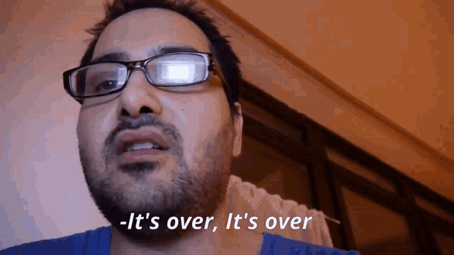 a man with glasses and a beard is saying it 's over