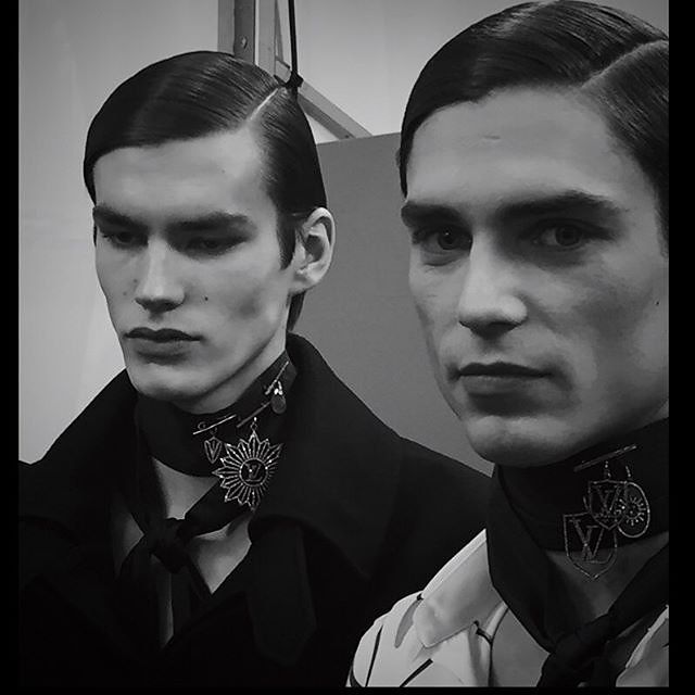 This may contain: two men wearing neck ties in front of a mirror with one man's face painted black and white