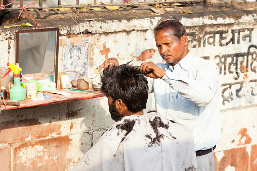 barber-cutting-hair-on-the-street-in-delhi-india-picture-id470107038