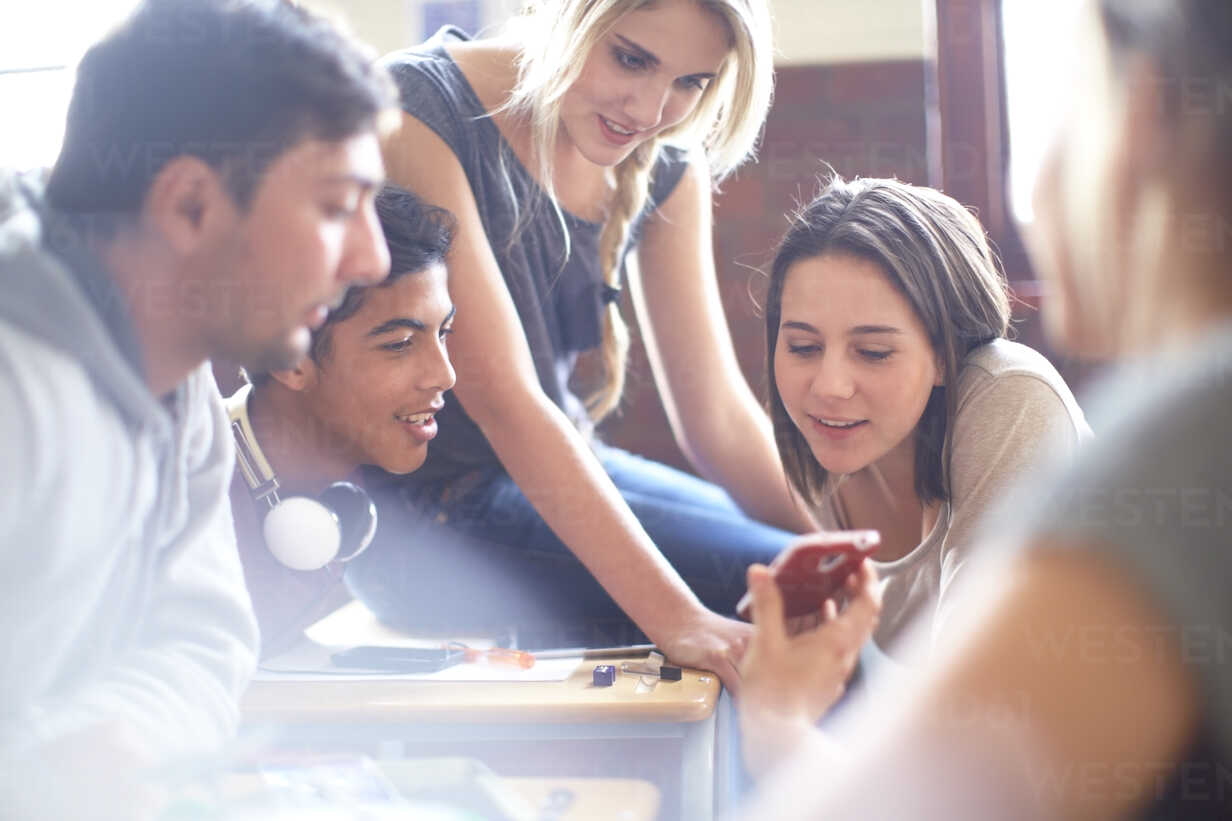 student-showing-cell-phone-to-classmates-in-classroom-ZEF000721.jpg