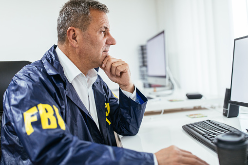 fbi-agent-using-computer-in-office-picture-id1171266229